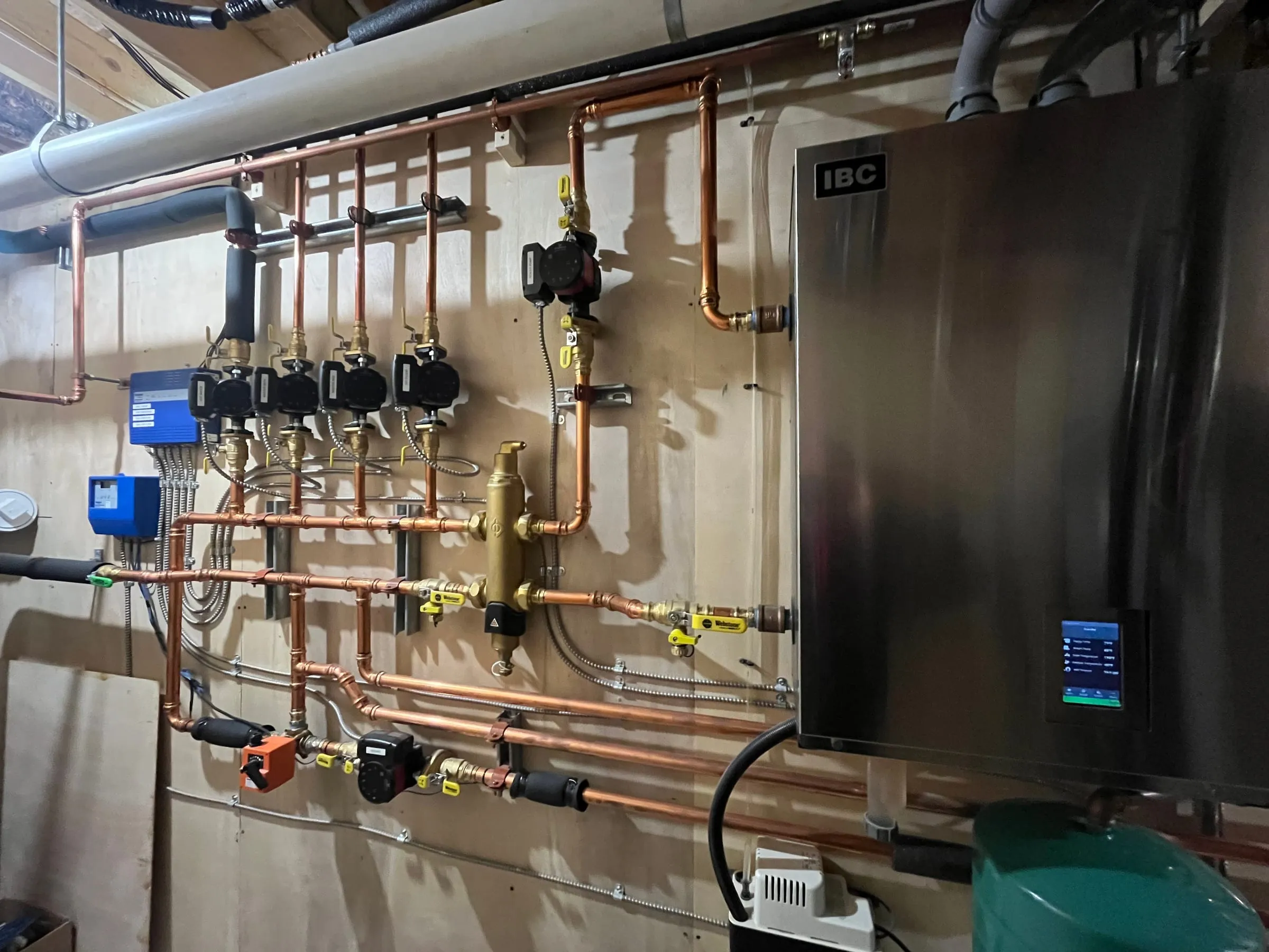 High-efficiency wall-hung boiler with a copper manifold and zone circulators installed by Mann's Heating & Air Conditioning