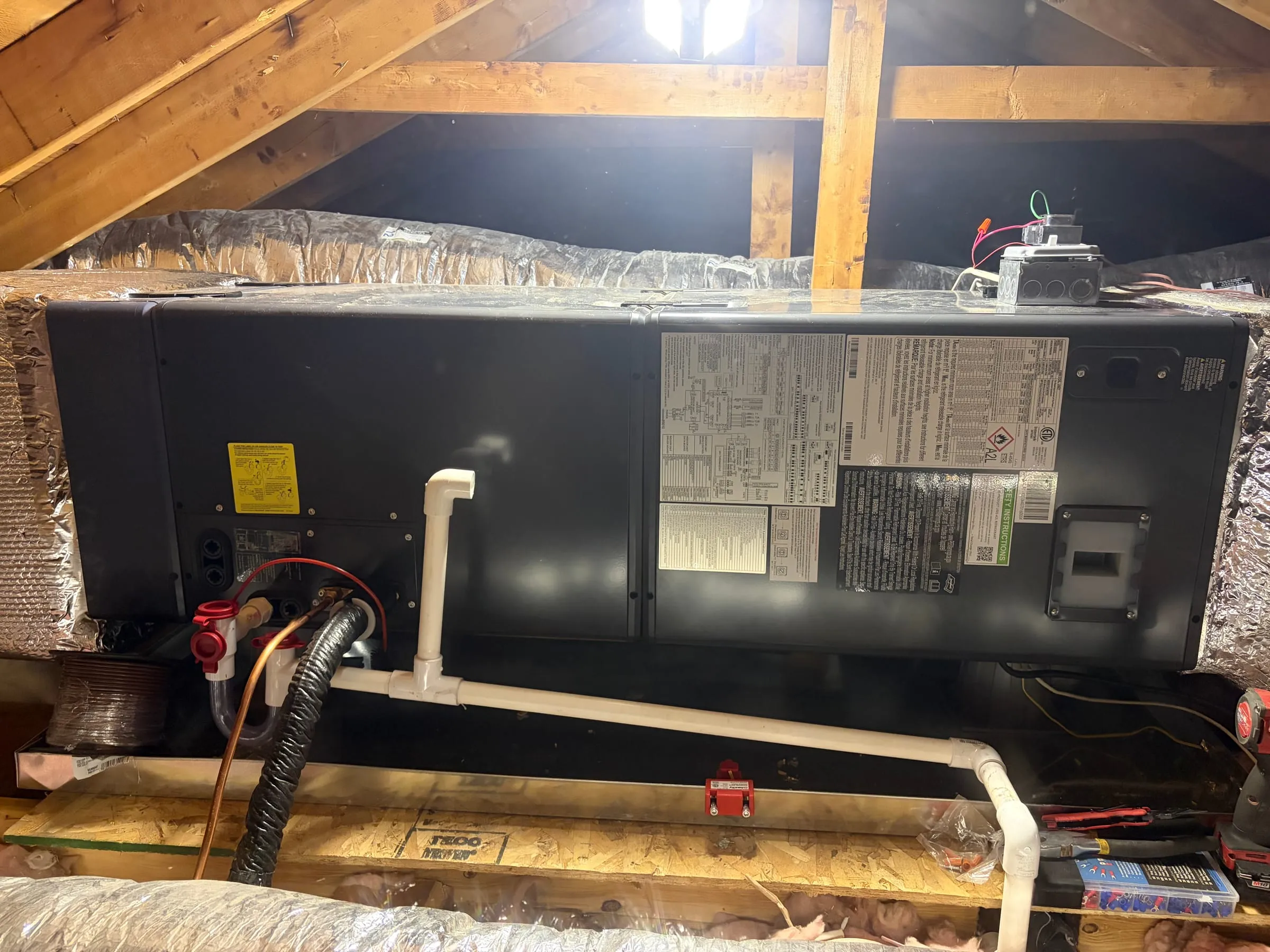 Ducted heat pump air handler installed in an attic with insulated ductwork