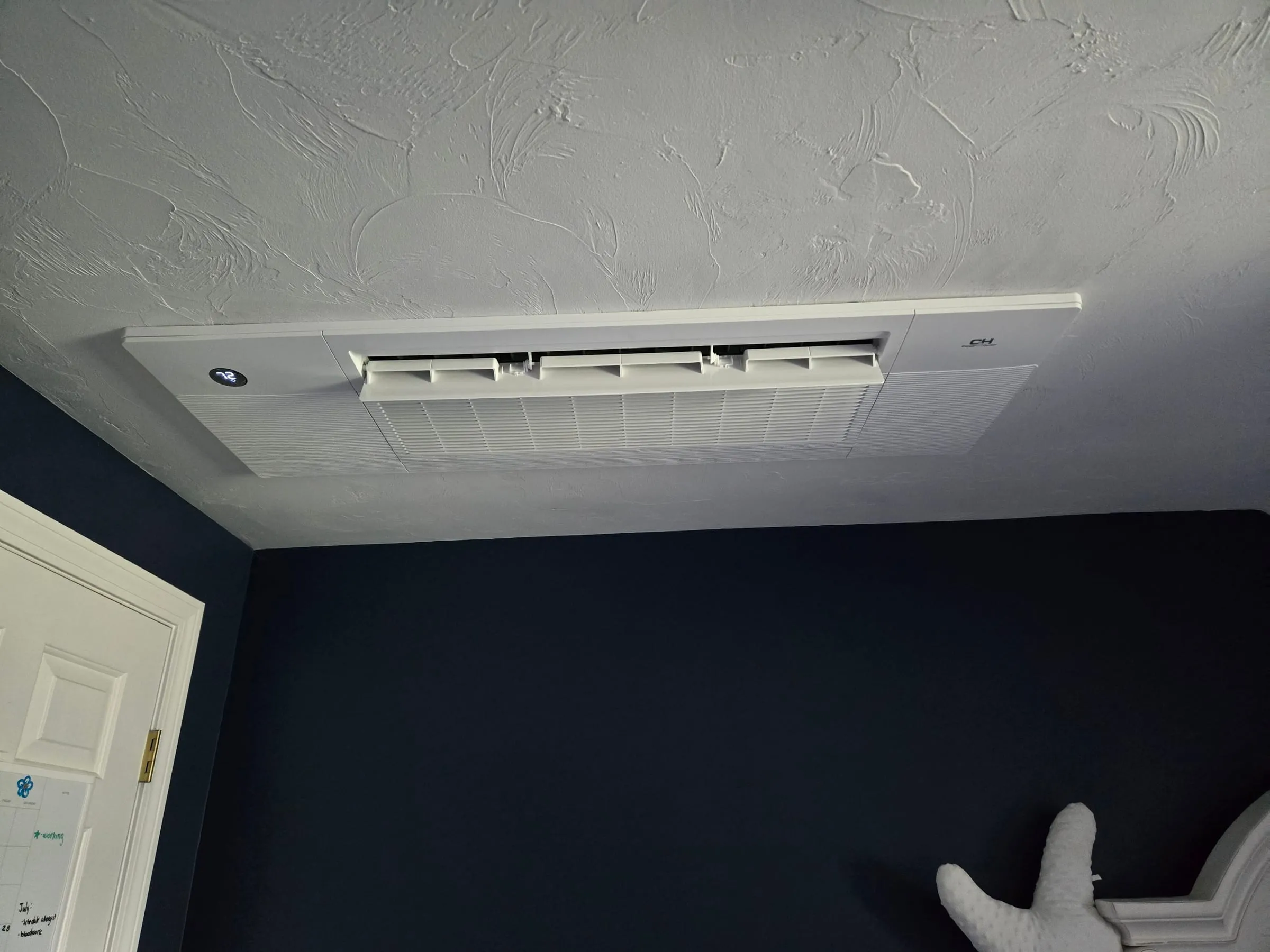 Ceiling-mounted heat pump head installed in a bedroom